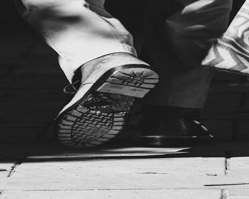 Close up of casual shoes walking on an urban sidewalk